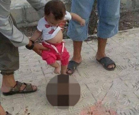 بالصورة: رضيع داعشييركل رأسًا مقطوعًا!